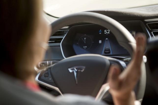 Tesla unveils autopilot system, but don’t let go of the wheel