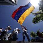 An anti-government student waves a Venezuelan flag during a protest rally in Caracas on February 16, 2014. Supporters and opponents of Venezuela's leftist government have been staging rival rallies amid spiraling discontent at the country's stubborn inflation and shortage of basic goods. Two anti-government protesters and a pro-Maduro demonstrator died in a rally early this week.    AFP PHOTO/JUAN BARRETO