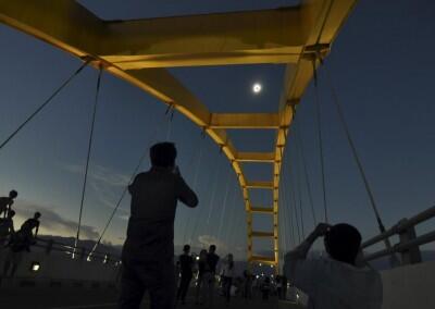 People watch a total solar eclipse from the Bay Bridge in Palu, Central Sulawesi, Indonesia March 9, 2016 in this photo taken by Antara Foto. REUTERS/Mohamad Hamzah/Antara Foto ATTENTION EDITORS - THIS IMAGE HAS BEEN SUPPLIED BY A THIRD PARTY. IT IS DISTRIBUTED, EXACTLY AS RECEIVED BY REUTERS, AS A SERVICE TO CLIENTS. FOR EDITORIAL USE ONLY. NOT FOR SALE FOR MARKETING OR ADVERTISING CAMPAIGNS MANDATORY CREDIT. INDONESIA OUT. NO COMMERCIAL OR EDITORIAL SALES IN INDONESIA.