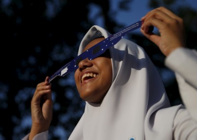 A school girl watches a partial solar eclipse at the Planetarium in Kuala Lumpur, Malaysia, March 9, 2016. REUTERS/Olivia Harris