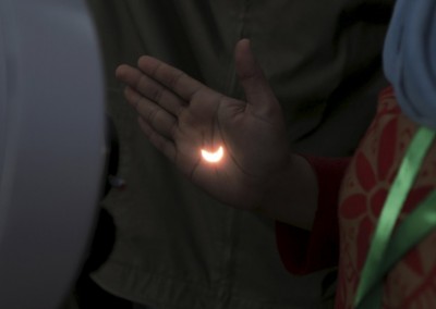 Light from a solar eclipse is reflected on a person's hand from a telescope on the Ampera Bridge over the Musi River in Palembang, South Sumatra province, Indonesia March 9, 2016 in this photo taken by Antara Foto.  REUTERS/Nova Wahyudi/Antara Foto