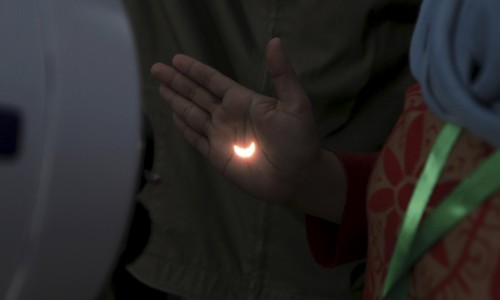 Light from a solar eclipse is reflected on a person's hand from a telescope on the Ampera Bridge over the Musi River in Palembang, South Sumatra province, Indonesia March 9, 2016 in this photo taken by Antara Foto. REUTERS/Nova Wahyudi/Antara Foto