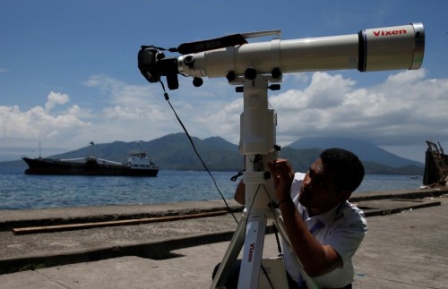 A staff of the Indonesian Agency for Meteorology, Climatology and Geophysics (BMKG) prepares a lens to record a solar eclipse at the beach of Ternate Island, Indonesia, March 8, 2016. REUTERS/Beawiharta