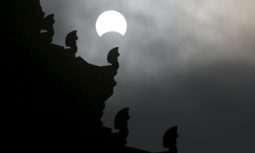 A partial solar eclipse is seen over the Independence Monument in Phnom Penh, Cambodia, March 9, 2016. REUTERS/Samrang Pring