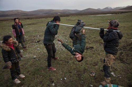 Tibetan nomads play after a day of working at a temporary camp for picking cordycep fungusKevin Frayer/Getty Images