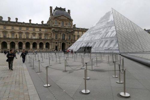 Tourists walk past empty waiting lines as the Louvre Museum is closed due to the rising Seine River in Paris, France, after days of almost non-stop rain caused flooding in the country, June 3, 2016. REUTERS/John Schults