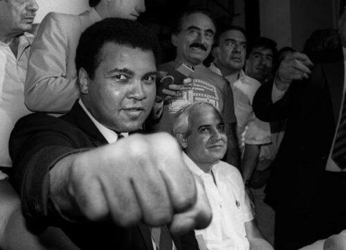 A smiling Muhammad Ali shows his fist to reporters during an impromptu press conference in Mexico City. REUTERS/Jorge Nunez