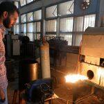 Engineering student, Mohamed Amr works near flame used in the process of burning car tires into diesel in Cairo