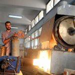 Engineering student, Mohamed Amr works near flame used in the process of burning car tires into diesel in Cairo