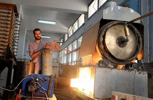 Engineering student, Mohamed Amr works near flame used in the process of burning car tires into diesel in Cairo