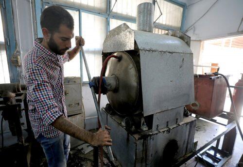 Engineering student, Mohamed Amr closes door of container used in burning car tires in Cairo